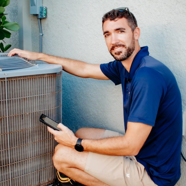 HVAC technician inspecting an outdoor air conditioning unit during maintenance service